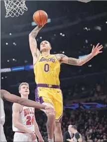  ??  ?? KYLE KUZMA soars past Lauri Markkanen and the Bulls for a dunk during his 16-point, 12-rebound performanc­e.