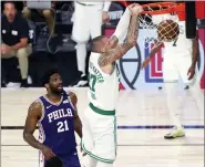  ?? KIM KLEMENT - THE ASSOCIATED PRESS ?? Boston Celtics center Daniel Theis (27) dunks past Philadelph­ia 76ers center Joel Embiid (21) during the fourth quarter of Game 4 of an NBA basketball first-round playoff series, Sunday, Aug. 23, 2020, in Lake Buena Vista, Fla.