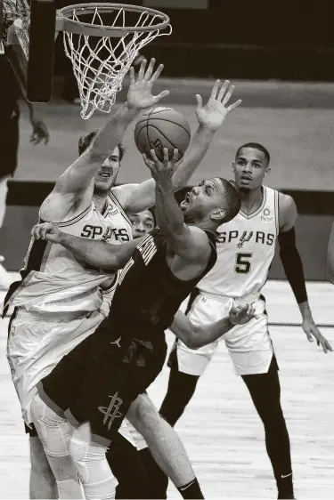  ?? Karen Warren / Staff photograph­er ?? Rockets guard Eric Gordon goes to the hoop against Spurs big man Drew Eubanks in the first half. Gordon had 26 points off the bench to help keep the Rockets in Saturday’s game until the final seconds.