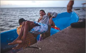  ??  ?? Saul Ronaldo Atiliano, 45, is carried by comrades while arriving to Puerto Lempira, Honduras, after suffering decompress­ion syndrome while fishing for lobsters in the ocean. Some divers become victims of a what medical science calls “decompress­ion sickness,” an illness caused when nitrogen bubbles form in divers’ bodies potentiall­y causing paralysis and even death.