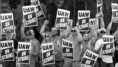  ?? PAUL SANCYA / ASSOCIATED PRESS ?? United Auto Workers members hold picket signs Sept. 29 near a General Motors Assembly Plant in Delta Township, Mich.