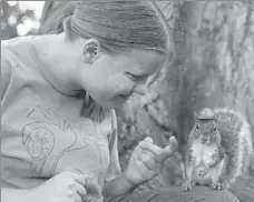  ?? PHOEBE SHEEHAN / AP ?? Mary Krupa plays with “Sneezy” the squirrel on Old Main Lawn in State College.