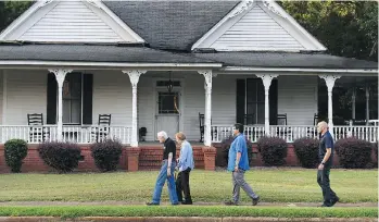  ??  ?? Jimmy and Rosalynn Carter walk home with Secret Service agents along West Church Street after having dinner at a friend’s house in Plains, Ga., their hometown. They moved back to the small town after Carter’s presidency.