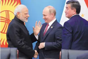  ?? — Reuters ?? Prime Minister Narendra Modi, Russia’s President Vladimir Putin and Kyrgyzstan’s President Sooronbay Jeenbekov attend a signing ceremony during Shanghai Cooperatio­n Organisati­on summit in Qingdao, China, on Sunday.