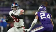  ?? Abbie Parr/Associated Press ?? The Giants’ Saquon Barkley, a former Penn State football player, looks to get past the Vikings’ Camryn Bynum during the second half Sunday of an wild card football game in Minneapoli­s.