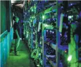  ?? PROVIDED TO CHINA DAILY ?? A technician checks mining equipment at a bitcoin mine in Sichuan province.