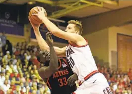  ?? MARCO GARCIA AP ?? Arizona forward Azuolas Tubelis goes for the basket through Aztecs forward Aguek Arop during first half of Tuesday night’s game.