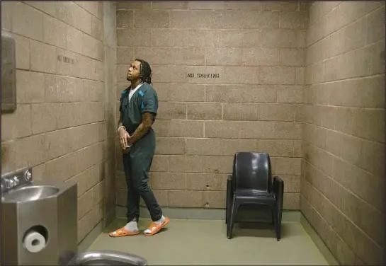  ?? ?? Zeron Moody waits in a basement holding cell at Cook County Jail before walking to the Leighton Criminal Court Building in October.