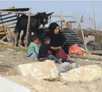  ??  ?? A Palestinia­n resident with her children in Khan Al Ahmar as Israeli law paves the way for the demolition of their village AFP