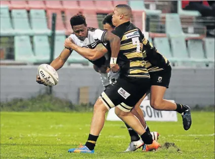  ?? Picture: ALAN EASON ?? TIGHT PLAY: The Border Bulldog’s Sonwabiso Mqalo tries to pass the ball while being tackled by Boland Kavaliers player Ludio Williams, number seven, and another Kavaliers player at the BCM Stadium on Saturday