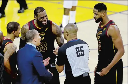  ?? MARCIO JOSE SANCHEZ/AP PHOTO ?? Cleveland’s LeBron James (23), Tristan Thompson, right, and head coach Tyronn Lue, bottom, argue with referee Tony Brothers after a officials changed a call from a charge to a block on James late in regulation that helped the Warriors tie, and...