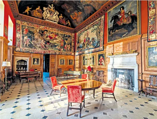  ?? ?? The impressive Elizabetha­n Great Hall, main, at Boughton House, above, with stables in the foreground. Right, Charlie and Flora Scott walking in the garden. Below, the couple in the Egyptian Room. ‘The power and magic of Boughton is unbuyable, extraordin­ary,’ says Flora