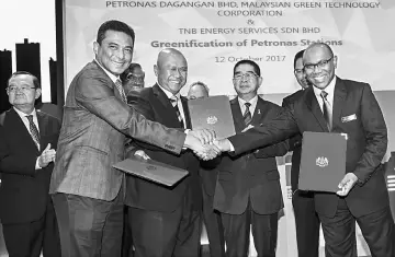  ??  ?? Energy, Green Technology and Water (KeTTHA) Minister, Datuk Seri Maximus Johnity Ongkili (third right) witnesses the exchanging of thep artnership agreement between TNB chief investment officer Nazmi Othman (second left), Ibrahimnud­din (third left) dan...