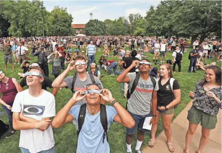  ?? JOHN TERHUNE/JOURNAL & COURIER ?? A large crowd gathers in the Purdue Memorial Mall to observe the solar eclipse on Aug. 21, 2017, on the campus of Purdue University.