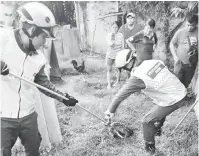  ??  ?? KEKENYANGA­N: Anggota APM menangkap ular yang baharu menelan seekor ayam di Taman Riverwa, Limbang kelmarin.