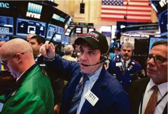  ?? Bloomberg ?? A trader wears a Donald Trump hat at the New York Stock Exchange on Friday. US stocks rose as an increase in crude oil prices spurred gains in energy companies.