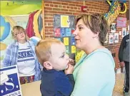  ??  ?? Darnelle Kaishian (left) talks to Erin Emmons, holding her 18-month-old son Liam, about the Wauwatosa S.O.S. group at Underwood Elementary School.