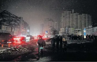  ?? SERGEY DOLZHENKO/EFE ?? Residentes caminham pelas ruas escuras de Kiev, sob a neve que já começa a cair na Ucrânia