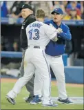  ?? BRAD WHITE/ GETTY IMAGES ?? Manager John Farrell ( right) restrains Brett Lawrie as umpire Bill Miller looks on. Both Blue Jays were ejected.