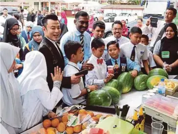  ??  ?? KAMALANATH­AN (tengah) bersama Datuk Aznil Nawawi pada majlis penyerahan Dana Bulan Bermakna Tesco di Sekolah Kebangsaan Taman Midah 2.