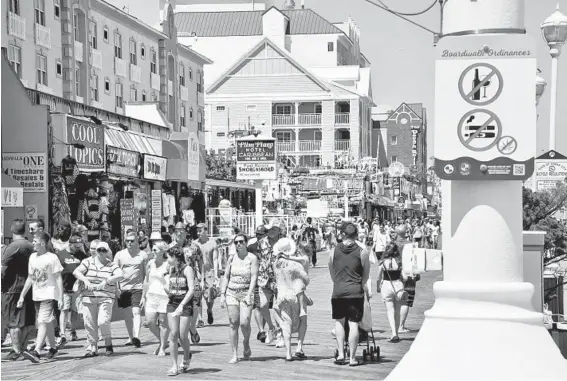  ?? AMY DAVIS/BALTIMORE SUN PHOTOS ?? Boardwalk ordinance signs, including warnings against alcoholic drinking, smoking and vaping, at right, are posted along the boardwalk.