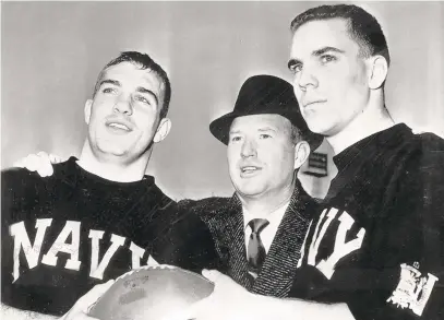  ?? AP WIRE PHOTO/BALTIMORE SUN ?? Navy head coach Wayne Hardin, center, poses with two of his stalwarts, Tom Lynch, left, and Heisman Trophy winner Roger Staubach leading up to the 1963 Army-Navy game in Philadelph­ia.