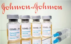  ?? REUTERS ?? Vials of coronaviru­s vaccine are seen in front of a displayed Johnson & Johnson logo in this illustrati­on shot on Oct 31 last year.