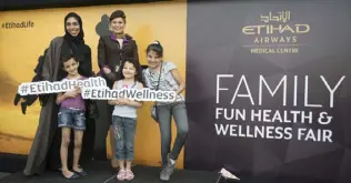  ??  ?? Dr. Nadia Bastaki, Etihad Airways vice president, medical services, with children of employees and a cabin crew member at the Etihad Airways family fun health and wellness fair