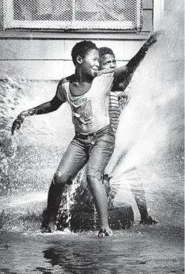  ?? JAMES MAYO/CHICAGO TRIBUNE ?? Children cool off in the spray from an open fire hydrant at Karlov and Maypole Avenues on Aug. 19, 1983, in Chicago.
