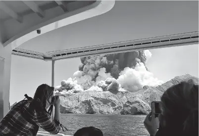  ??  ?? This handout photograph by courtesy of Michael Schade shows the volcano on New Zealand’s White Island spewing steam and ash moments after it erupted yesterday. — AFP