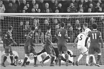  ??  ?? Swansea City’s English defender Alfie Mawson (2nd R) watches his shot beat Liverpool’s German goalkeeper Loris Karius (C) to open the scoring during the English Premier League football match between Swansea City and Liverpool at The Liberty Stadium in...