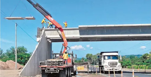  ??  ?? Instalando. El nuevo puente tiene suficiente amplitud para el paso de vehículos, ganado y peatones. Es uno de cuatro a construirs­e en ese tramo.