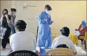  ?? PARVEEN KUMAR/HT ?? A health worker holds a swab sample after collecting it from a woman in Gurugram on Saturday.