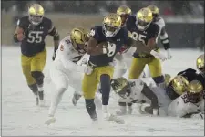  ?? DARRON CUMMINGS — THE ASSOCIATED PRESS ?? Notre Dame running back Logan Diggs is tackled in the snow by Boston College linebacker Bryce Steele during the second half. Notre Dame blew out the Eagles, 44-0, in South Bend, Ind.