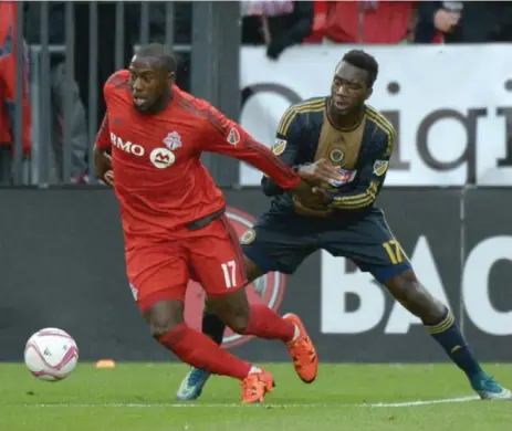  ?? JON BLACKER/THE CANADIAN PRESS ?? Toronto FC’s Jozy Altidore fends off Philadelph­ia’s C.J. Sapong during first-half play at BMO Field on Saturday. Altidore scored in the Reds’ 3-1 victory.