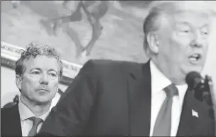  ??  ?? U.S. Senator Rand Paul (R-KY) listens as U.S. President Donald Trump speaks before signing an executive order making it easier for Americans to buy bare-bones health insurance plans and circumvent Obamacare rules at the White House in Washington, U.S.,...