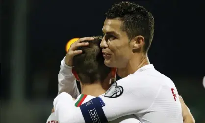  ??  ?? Cristiano Ronaldo celebrates with Bernardo Silva after scoring his fourth goal in Portugal’s 5-1 win over Lithuania in Vilnius. Photograph: Mindaugas Kulbis/AP