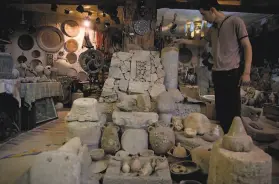  ?? Khalil Hamra / Associated Press ?? A Palestinia­n looks at ancient artifacts displayed inside a private museum in the basement of a building in Khan Younis, Southern Gaza Strip.