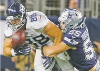  ?? MICHAEL AINSWORTH/ASSOCIATED PRESS ?? Titans tight end Luke Stocker, left, bobbles the ball as Cowboys linebacker Leighton Vander Esch defends during Monday’s game.