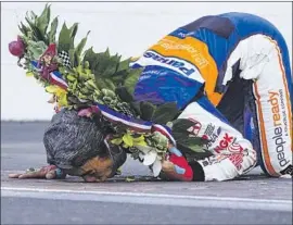  ?? Michael Conroy Associated Press ?? TAKUMA SATO kisses the yard of bricks on the start/finish line after winning an unusual running of the Indianapol­is 500 at Indianapol­is Motor Speedway.