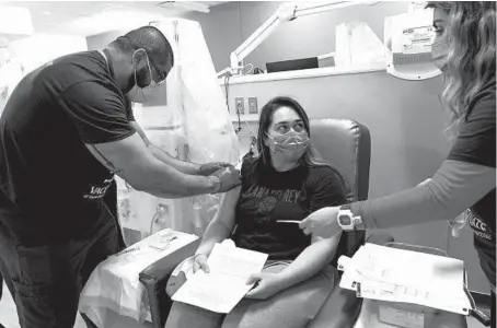  ?? ERIN HOOLEY/CHICAGO TRIBUNE PHOTOS ?? Wendolyn Reyes, 19, receives a Pfizer COVID-19 vaccine during a mass vaccinatio­n event held May 2 by St. Anthony Hospital in the Little Village neighborho­od of Chicago. St. Anthony hired about 80 people to go into communitie­s for the vaccine effort.