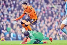  ??  ?? Manchester City’s Chilean goalkeeper Claudio Bravo saves at the feet of Wolverhamp­ton Wanderers’ Portuguese striker Helder Costa during the English League Cup fourth round football match between Manchester City and Wolverhamp­ton Wanderers at the Etihad...