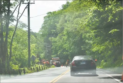  ?? Kendra Baker / Hearst Connecticu­t Media ?? State Department of Transporta­tion workers repair wooden guide rail posts on Route 7 inn New Milford Wednesday that were damaged after a dump truck broke through them and rolled into the Housatonic River the day before.