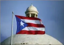  ?? RICARDO ARDUENGO — THE ASSOCIATED PRESS FILE ?? In this file photo, the Puerto Rican flag flies in front of Puerto Rico’s Capitol in San Juan, Puerto Rico. The Government Accountabi­lity Office released a report on Wednesday that sheds more light on how Puerto Rico accumulate­d some $70 billion in...