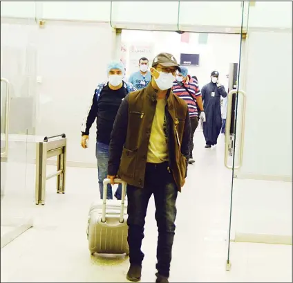  ?? Photo by Samer Shiker ?? Kuwaitis with masks seen during their arrival from Iran where there has been confirmed cases of people suffering from coronaviru­s.