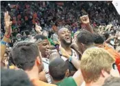  ?? DAVID SANTIAGO/EL NUEVO HERALD ?? Hurricanes players and fans celebrate Saturday after the team defeated Duke, 55-50, in Coral Gables.