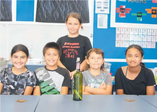  ??  ?? The Year 5-6 pupils’ first job is find a way of extracting the card from the bottle without breaking it.
Awanui School pupils Charlie Ujdur, Remedy Matthews, Keira Job, Eleigen Cuttle, Destiny Wharewaka Tawhai and Bayley Norman (absent) have taken the job of finding out the story behind the card in a bottle.