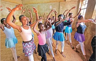  ??  ?? Young ballerinas receive instructio­n from Kenyan ballet dancer Joel Kioko, 16, in a room at a school in the Kibera slum of Nairobi, Kenya.