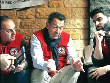  ?? HAMZA AL-AJWEH/AFP ?? Peter Maurer (centre), president of the Internatio­nal Committee of the Red Cross, talks with aid workers after arriving in the rebel-held town of Douma in Eastern Ghouta on March 17.