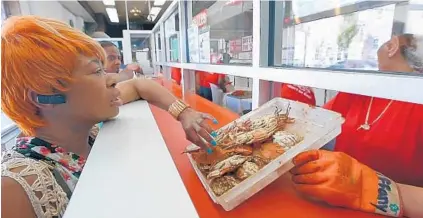  ?? KARL MERTON FERRON/BALTIMORE SUN PHOTOS ?? Patricia Blackston of Baltimore examines steamed crabs at Bay Island Crab House in Baltimore. A winter dredging to estimate the crab population indicated a 35 percent increase over last season. Male and female crabs were found to be more numerous.